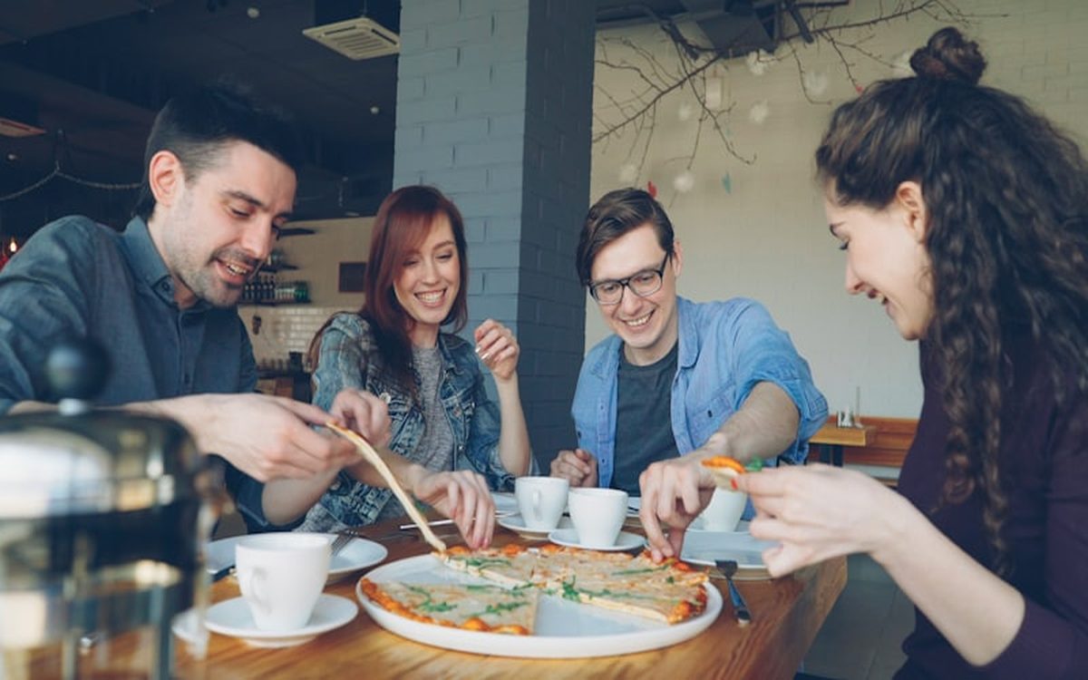 Arkadaş grubu birlikte pizza yerken